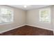 Bedroom featuring hardwood floors, neutral walls, and two windows with white trim at 116 W Mciver St, Zebulon, NC 27597