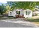 Cozy one-story home featuring a gravel driveway, quaint porch, and comfortable outdoor space at 116 W Mciver St, Zebulon, NC 27597