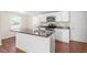 Well-equipped kitchen with white cabinets, stainless appliances, and granite-topped island at 116 W Mciver St, Zebulon, NC 27597