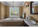 A luxurious bathroom featuring a soaking tub, separate vanity, and classic fixtures at 1174 Robertson Rd, Roxboro, NC 27574