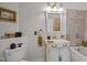 Bathroom featuring classic vanity, ornate fixtures, and tub with tiled surround at 1174 Robertson Rd, Roxboro, NC 27574