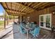 Large, covered patio with brick wall, wood ceiling, and comfortable patio furniture, perfect for relaxing and entertaining at 1174 Robertson Rd, Roxboro, NC 27574