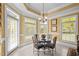 Bright dining area with glass table, chandelier, and lots of natural light from surrounding windows at 1174 Robertson Rd, Roxboro, NC 27574