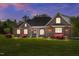 Charming brick home featuring a well-manicured lawn and a welcoming entrance with stately columns at 1174 Robertson Rd, Roxboro, NC 27574
