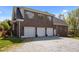 Large, brick three car garage with white doors and an ample parking area at 1174 Robertson Rd, Roxboro, NC 27574