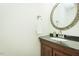 Stylish powder room with a black granite countertop, decorative mirror, and modern fixtures at 127 Long Shadow Pl, Durham, NC 27713