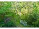 Lush backyard with mature trees and flowering plants creating a serene outdoor space at 127 Long Shadow Pl, Durham, NC 27713