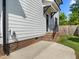 Side view of home featuring modern white siding, brick accents, and a convenient EV charger at 1312 Lancaster St, Durham, NC 27701