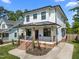 Charming two-story home featuring a covered front porch with brick stairs and black railing at 1312 Lancaster St, Durham, NC 27701