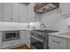 Modern kitchen features stainless steel appliances, white cabinetry and subway tile backsplash at 1312 Lancaster St, Durham, NC 27701