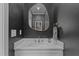 Stylish powder room featuring dark walls, a modern vanity, and a decorative mirror at 1312 Lancaster St, Durham, NC 27701