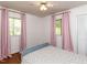 Bright bedroom featuring hardwood floors, two windows, and neutral-toned walls for a relaxing atmosphere at 1317 Kelly Rd, Garner, NC 27529