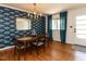 Dining room featuring hardwood floors, stylish wallpaper, and a charming chandelier at 1317 Kelly Rd, Garner, NC 27529