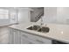Close-up of a kitchen island featuring stainless steel sink, faucet, and granite countertop at 1335 Herb Garden Way, Apex, NC 27502