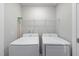 Bright laundry room with Samsung washer and dryer and wire rack at 1335 Herb Garden Way, Apex, NC 27502