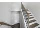 Staircase featuring stained wood treads, white risers, and decorative black metal railing at 1335 Herb Garden Way, Apex, NC 27502