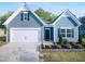 Charming blue home with a well-manicured lawn and an attached garage at 136 W Tecoma Ln, Clayton, NC 27520