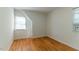 Bedroom with hardwood floors, white walls, and window with AC unit at 1408 Edgebrook Dr, Garner, NC 27529