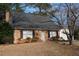 Brick home with black shutters, a gray roof, and a detached white garage at 1408 Edgebrook Dr, Garner, NC 27529