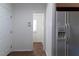 Inviting hallway with tiled floor that leads to a bright room, plus a white refrigerator with water and ice dispenser at 1408 Edgebrook Dr, Garner, NC 27529