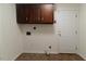 Laundry room with upper cabinets, hookups, tile floor, and access to the exterior via a white door at 1408 Edgebrook Dr, Garner, NC 27529