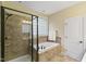 Bathroom with glass shower and tub, featuring tile and a window at 144 Cobble Ridge Dr, Pittsboro, NC 27312
