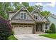 Charming home featuring a stone facade, gray siding, a well-manicured lawn, and an attached two-car garage at 144 Cobble Ridge Dr, Pittsboro, NC 27312