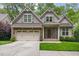 Charming home featuring a stone facade, gray siding, a well-manicured lawn, and an attached two-car garage at 144 Cobble Ridge Dr, Pittsboro, NC 27312