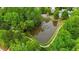 Scenic aerial view of a community pond featuring a walking path and mature trees at 144 Cobble Ridge Dr, Pittsboro, NC 27312