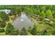 Picturesque aerial view of a community pond with a fountain surrounded by lush greenery and trees at 144 Cobble Ridge Dr, Pittsboro, NC 27312