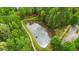 Overhead view of community pond with fountain, edged by sidewalks and mature trees at 144 Cobble Ridge Dr, Pittsboro, NC 27312