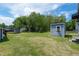 Expansive backyard with a shed, swing set, mature trees, and trampoline, perfect for outdoor enjoyment at 1542 Albright Ave, Burlington, NC 27215
