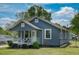 Charming blue home featuring a cozy front porch, white trim, and well-maintained landscaping at 1542 Albright Ave, Burlington, NC 27215
