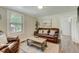 Inviting living room with a cozy leather couch, neutral rug, and natural light from a window at 1542 Albright Ave, Burlington, NC 27215