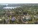 Aerial view of community, showcasing homes surrounded by lush trees and a sparkling lake at 157 Maplewood Dr, Sanford, NC 27332