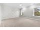 Bedroom with a decorative accent wall, carpet, and large windows with wooded views at 157 Maplewood Dr, Sanford, NC 27332