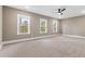 Spacious bedroom with carpet, three windows that allow for lots of natural light, and a ceiling fan at 157 Maplewood Dr, Sanford, NC 27332