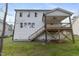 Back of home showing deck, staircase, white siding, green grass, and many windows at 157 Maplewood Dr, Sanford, NC 27332