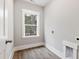 Bright laundry room features a window, gray walls, wood-look floors, and washer/dryer hookups at 157 Maplewood Dr, Sanford, NC 27332