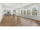 Bright open-concept living area featuring hardwood floors, recessed lighting, and large windows with a wooded view at 157 Maplewood Dr, Sanford, NC 27332