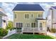 Back exterior of the house featuring a spacious yard, deck, and partial white picket fencing at 161 Fort Jackson Rd, Morrisville, NC 27560