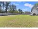 Vast backyard with a green lawn, enclosed by a wooden fence, offering privacy and ample space for outdoor activities at 166 Old Field Loop Loop, Sanford, NC 27332