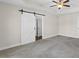 Large main bedroom with barn door to ensuite bathroom, ceiling fan, and tray ceiling at 166 Old Field Loop Loop, Sanford, NC 27332