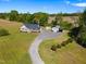 Charming home with a inviting front porch, complemented by a detached garage and shed, framed by lush landscaping at 175 Bill Avery Rd, Coats, NC 27521
