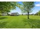 Expansive backyard featuring a lush lawn, outbuildings and mature trees, offering ample outdoor space at 175 Bill Avery Rd, Coats, NC 27521