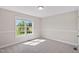 Sunny bedroom with carpeted floors, neutral walls and a large window offering views of the outdoors at 175 Bill Avery Rd, Coats, NC 27521