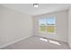 Bright, carpeted bedroom features a large window providing natural light and views of the surrounding greenery at 175 Bill Avery Rd, Coats, NC 27521