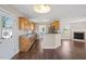 Open concept kitchen with wood cabinets, stainless steel appliances, and a view of the fireplace at 175 Bill Avery Rd, Coats, NC 27521