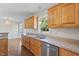 Spacious kitchen with wood cabinets, stainless steel dishwasher, and wood flooring throughout at 175 Bill Avery Rd, Coats, NC 27521