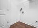 Functional laundry room with white walls, wood-look floors, wire shelving, and essential utility connections at 175 Bill Avery Rd, Coats, NC 27521